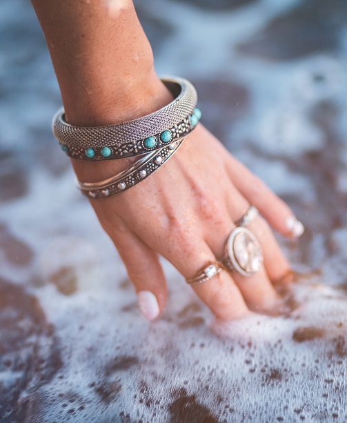 Hand mit Silberschmuck in Wasser